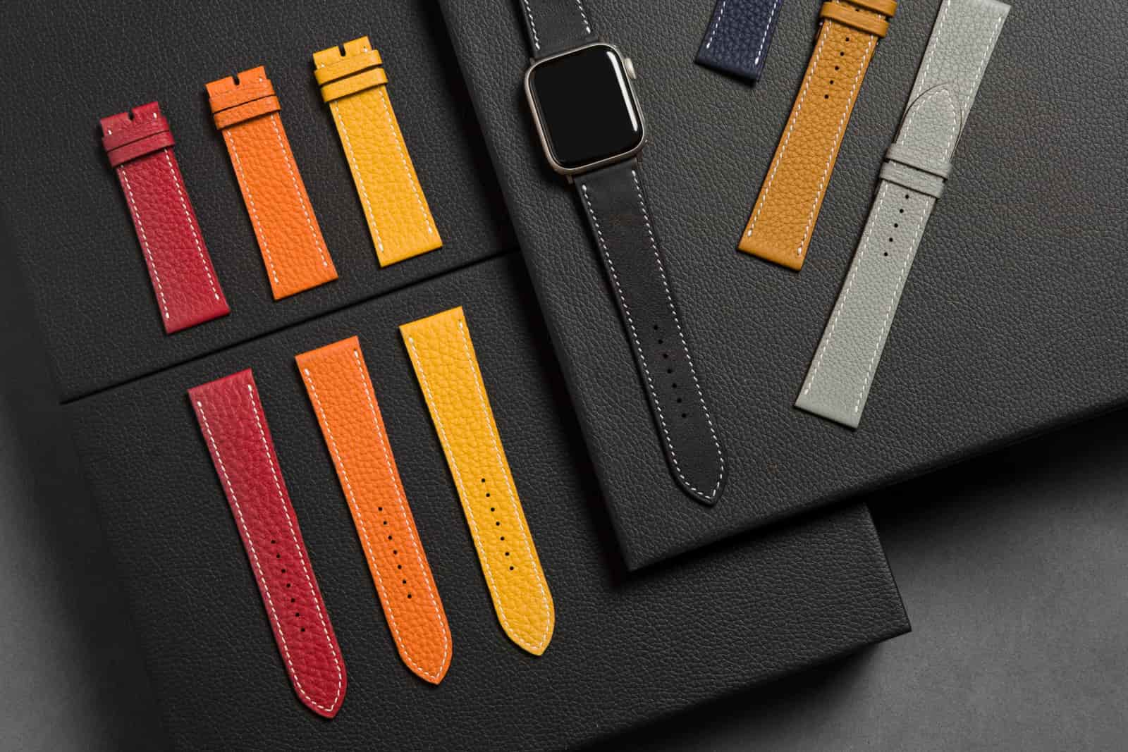 Coloured calf leather watch straps staged on black folios, showing the same palette against a dark ground, made by AKC