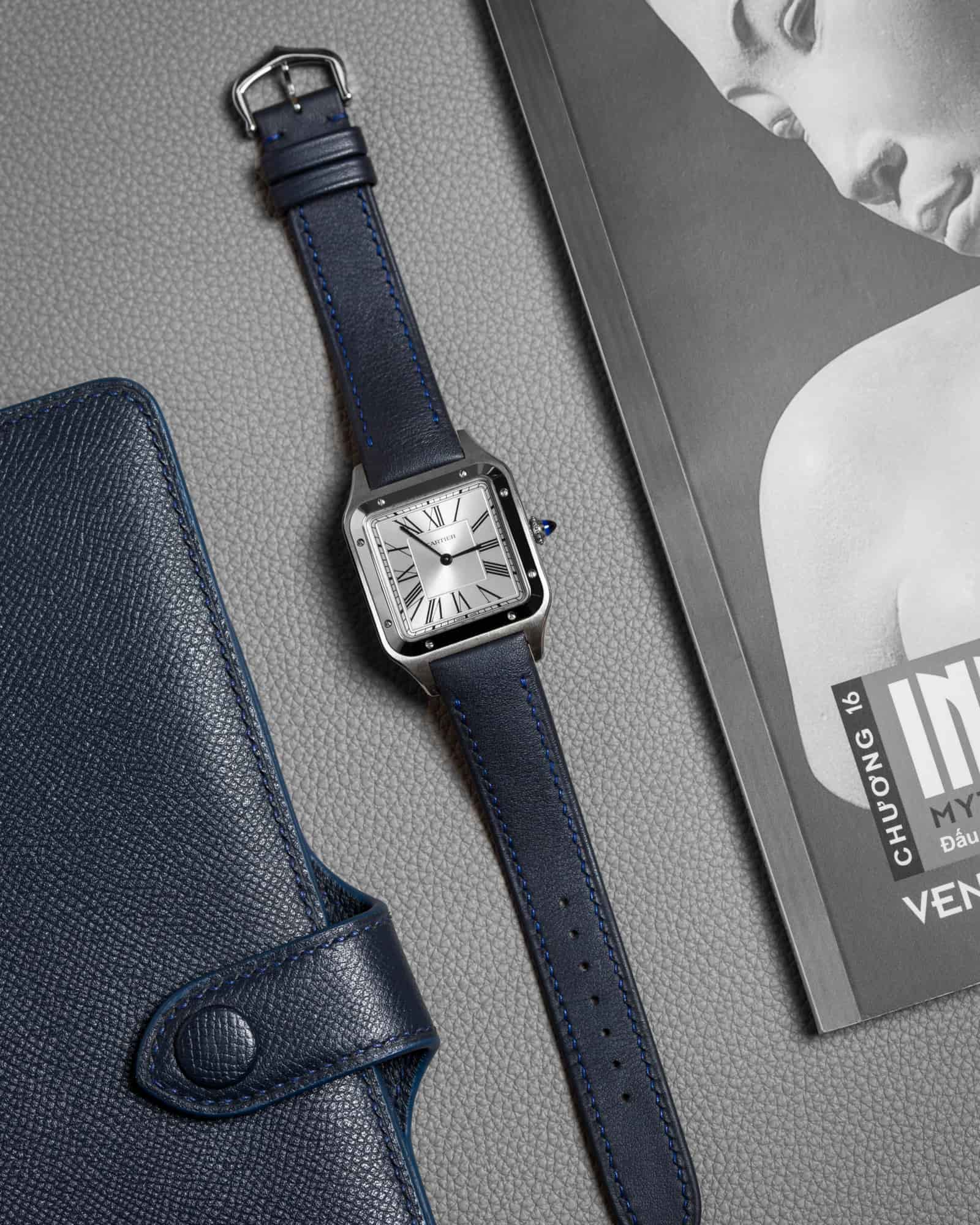 Navy calf leather watch strap fitted to a Cartier Santos-Dumont, photographed upright to show the taper from lug to buckle, made by AKC