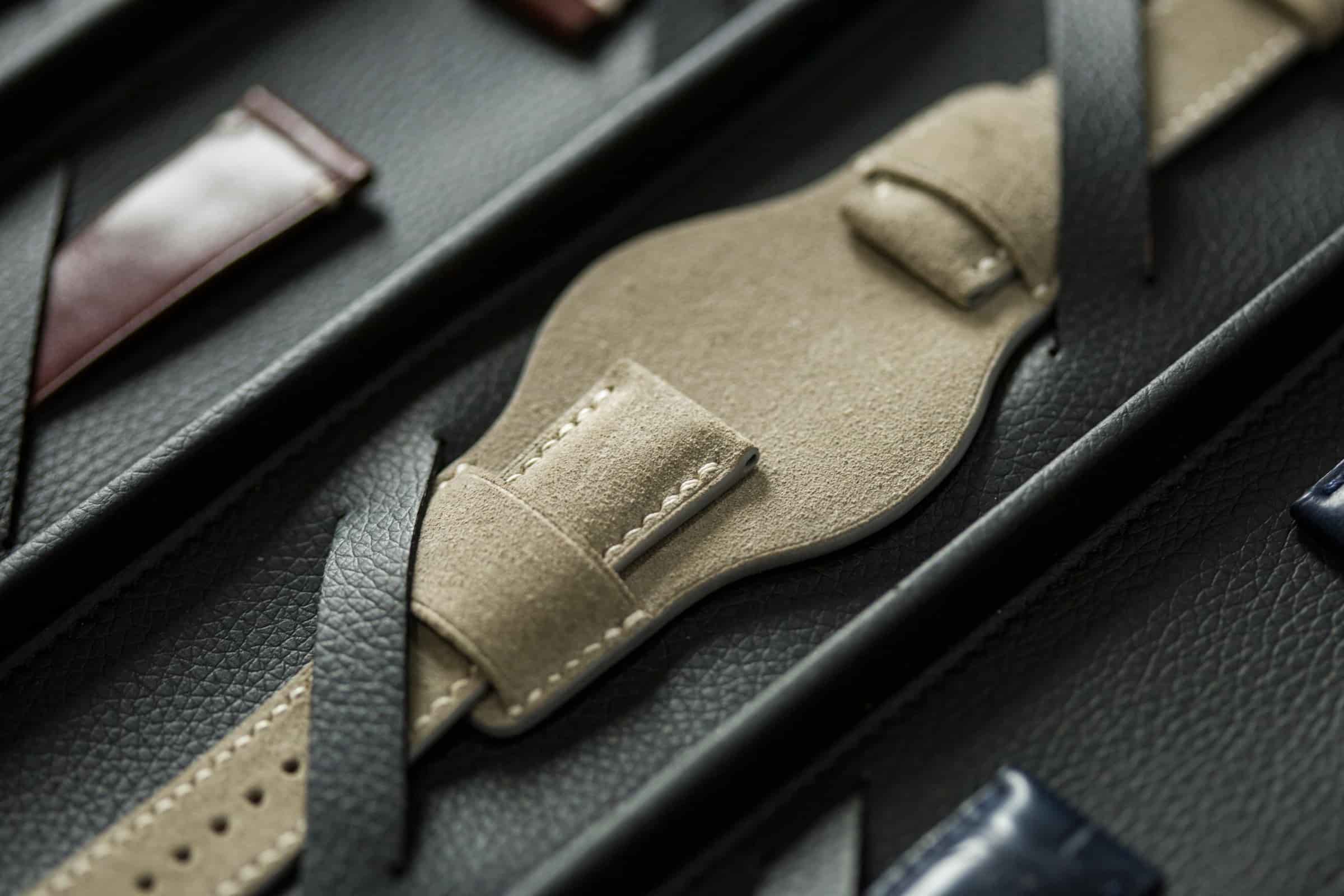 Macro photograph of a suede leather bund watch pad, showing the brushed nap, the burnished edge and the hand stitching, by AKC